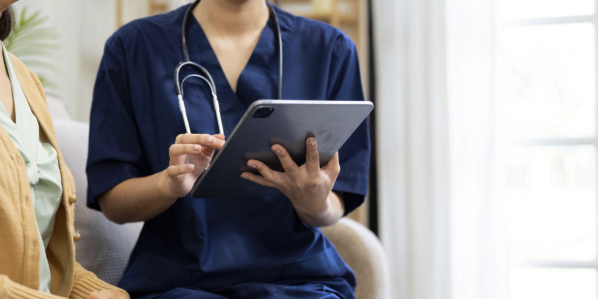 caregiver using tablet to manage health records of elderly patient